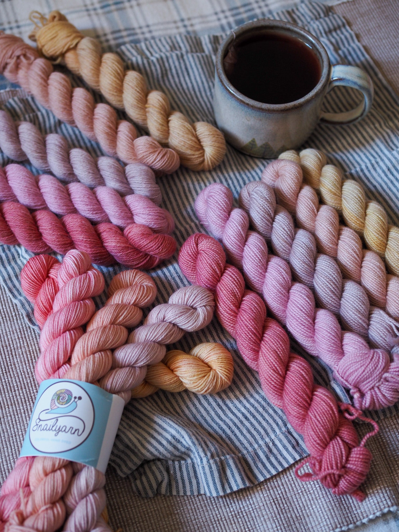 Hand-dyed 5 mini-skein yarn set by Snail Yarn in botanical shades of dusty pink, peach, and mauve, inspired by English roses. High-quality Merino and Peruvian wool for knitting and colorwork.