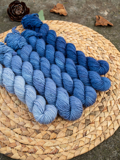 5 mini skeins of hand dyed yarn in a gradient/fade set in color denim blue.